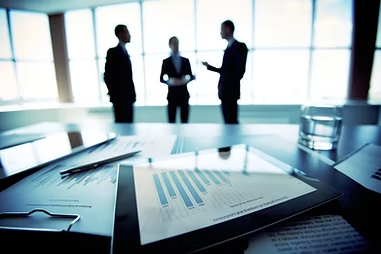 Business leaders in discussion beside a table of reports