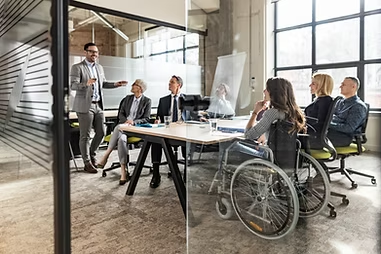 A facilitator presenting to a team in a glass-walled meeting room